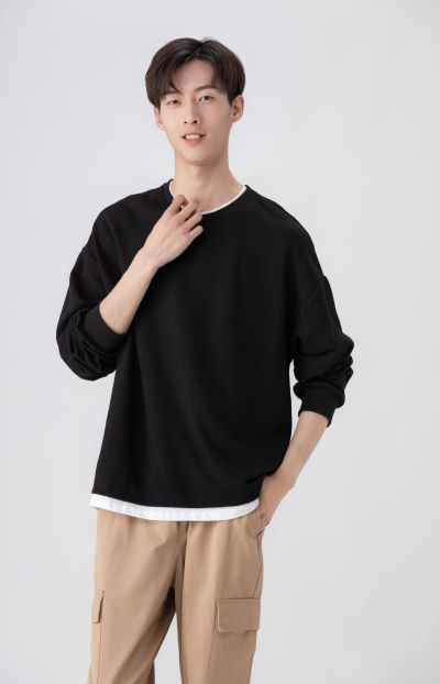 服饰系列实景模特穿着黑色卫衣和卡其色长裤的室内摆拍