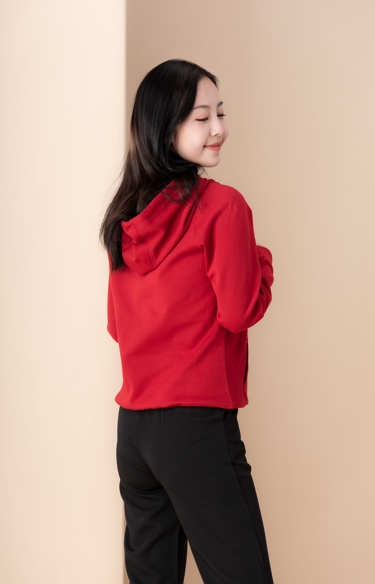 服饰系列实景模特穿着红色卫衣和黑色长裤的室内摆拍