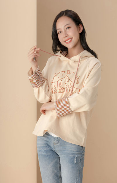 服饰系列实景模特穿着杏色卫衣和蓝色牛仔裤的室内摆拍