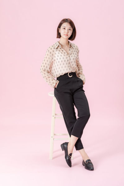 服饰系列实景模特穿着杏色衬衫搭配牛仔短裙、黑色长裤、灰色百褶裙的室内摆拍