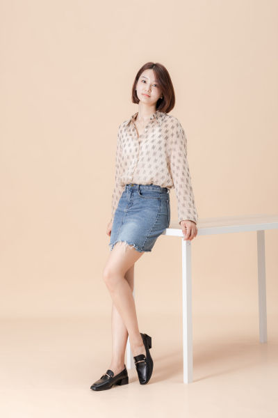 服饰系列实景模特穿着杏色衬衫搭配牛仔短裙、黑色长裤、灰色百褶裙的室内摆拍