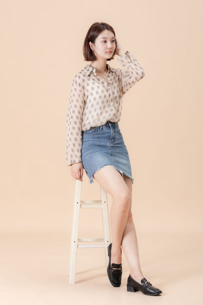 服饰系列实景模特穿着杏色衬衫搭配牛仔短裙、黑色长裤、灰色百褶裙的室内摆拍