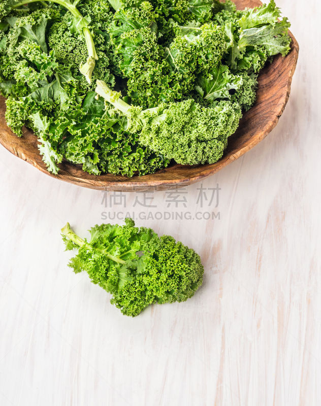 raw  kale preparation on white wooden table