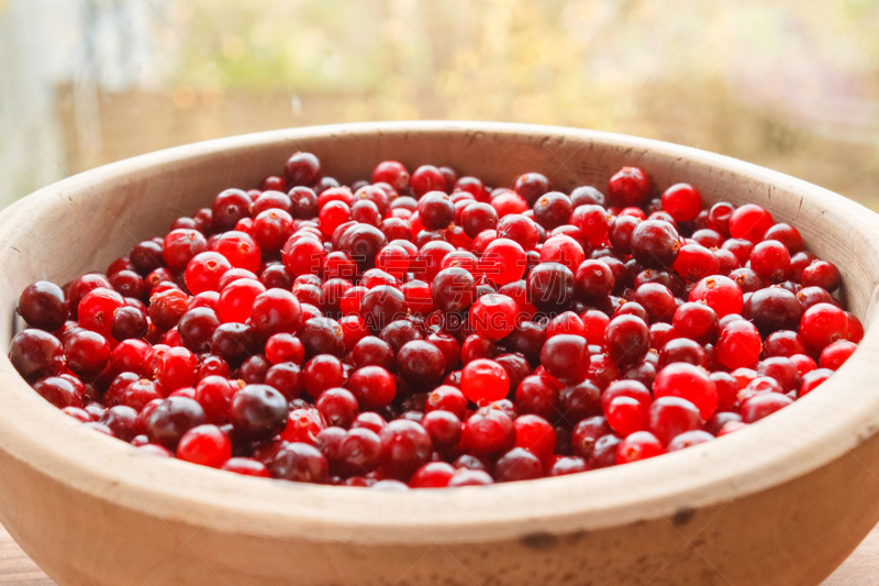 Red berries in a wooden bowl