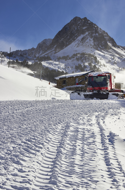 Red snow groomer in the mountain