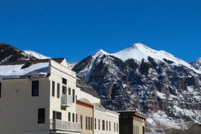 Tan store fronts in Telluride with a large mountain peak