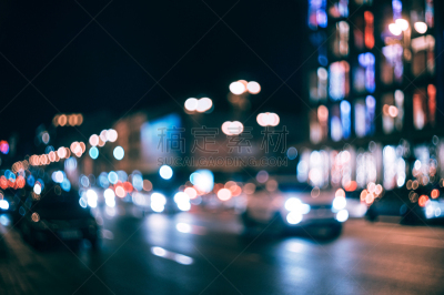 Blurred city at night. Bokeh. Beautiful abstract background with defocused buildings, cars, city lights, people. Colorful bokeh background with urban night scene. Design. Concept backdrop. Vintage