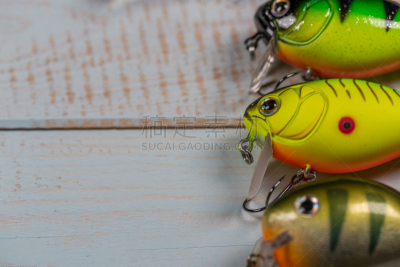 Fishing lures side by side on wooden background