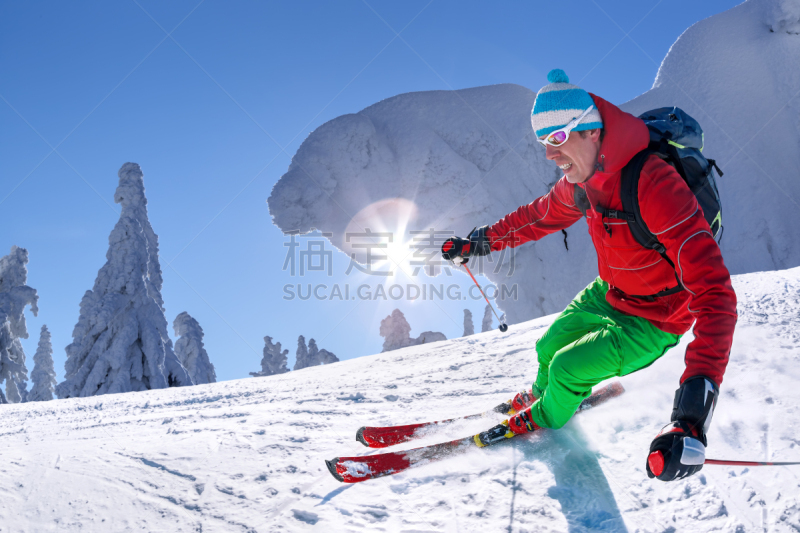 Skier skiing downhill in high mountains against blue sky