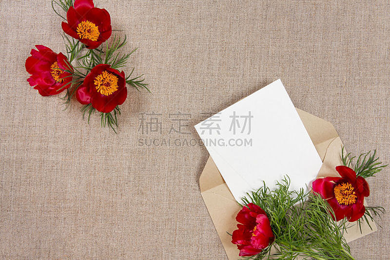 Сard with an envelope and red flowers on beige fabric