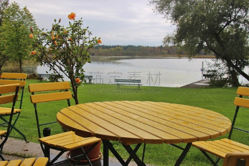 Table and chairs on the Lido of  Ibm lake, or Heratinger lake, in Upper Austria, in autumn. It’s rainy weather. A nature reserve next to the Ibm moorland. Ibm, Upper Austria, Europe.