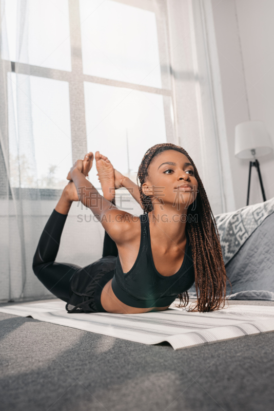 woman practicing yoga in bow pose