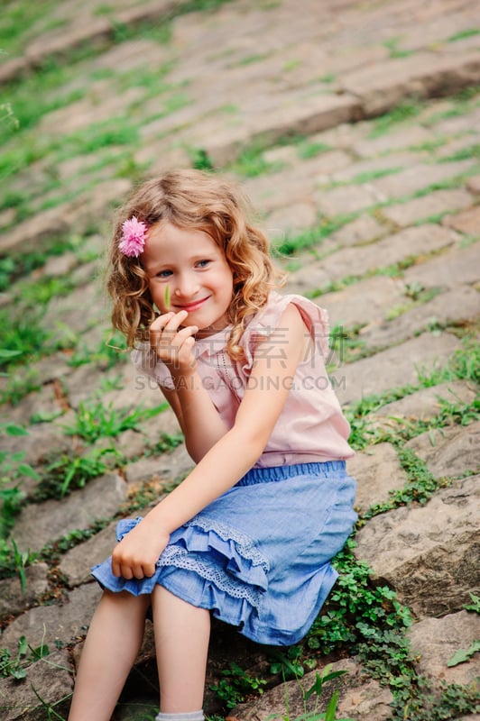 kid girl on the walk in old city near wall