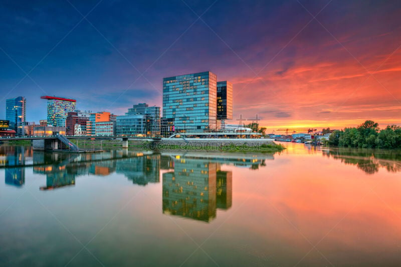 Cityscape image of Düsseldorf, Germany with the Media Harbour and reflection of the city in the Rhine river, during beautiful sunset.