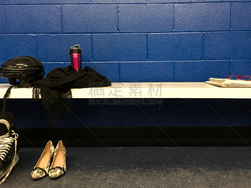 Women’s hockey skate and helmet with heels in locker room after work with copy space