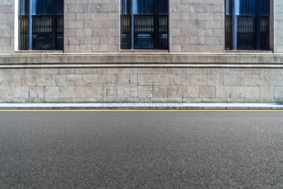 empty asphalt road front of the wall