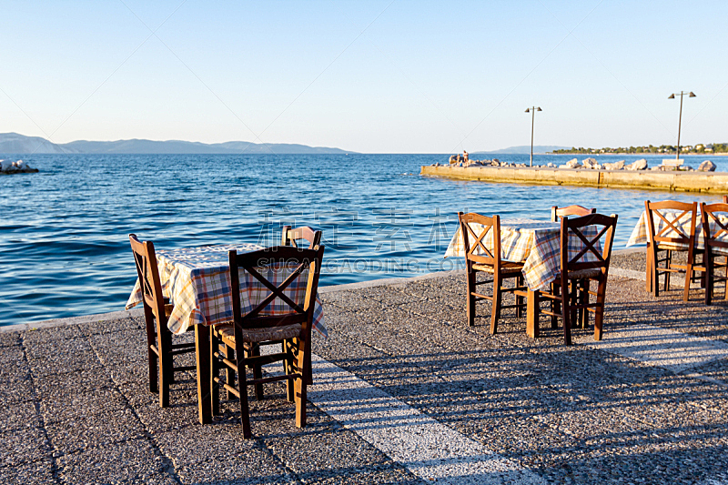 Evening at traditional Greek tavern, restaurant by the open sea