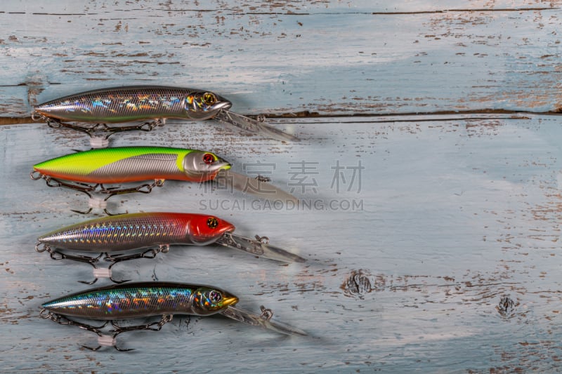 Spinner lures on a blue wooden background