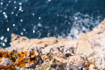 Rocks at seashore of Adriatic sea, Mediterranean, closeup. Stone, rocks, red algae and sea, shore and stones. Beautiful landscapes, seaside, natural light, natural masterpiece, rocks at a beach.