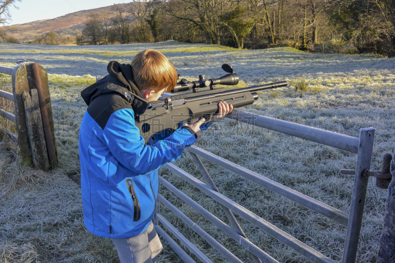 Young boy shooting with air rifle (landscape)