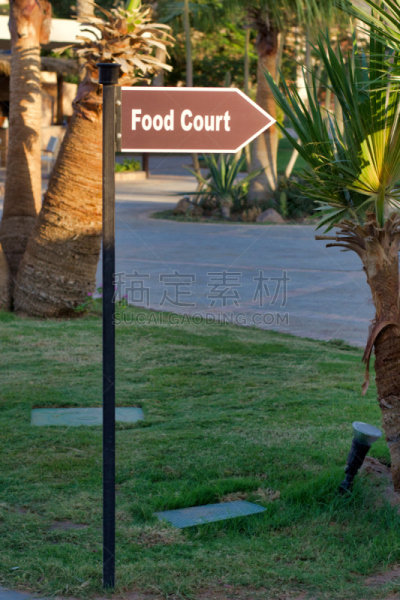 Pointer to the food court in outdoors, in the form of an arrow on a metal column.