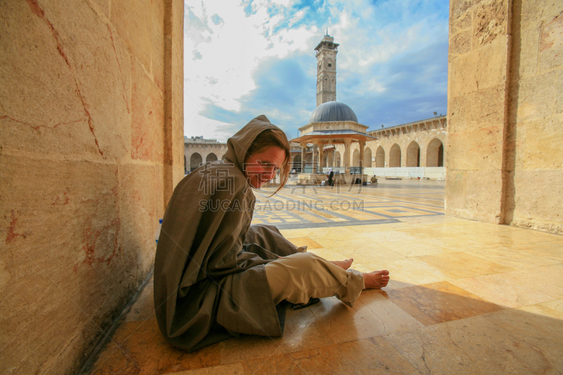 Aleppo, Syria - September 29, 2008: Syria before the war. Foreign woman traveler in the main courtyard of the Great Mosque of Aleppo or Umayyad Mosque before its destruction as a result of the fighting during The Battle of Aleppo (2012–2016). It was the l