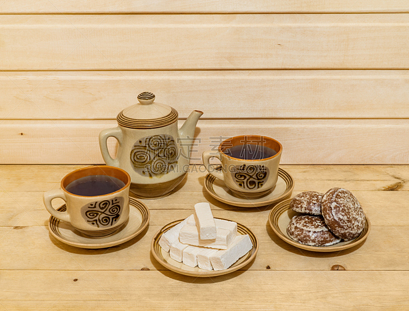 Pastry and tea-set on wooden background