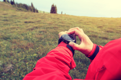 hands checking the altimeter on sports watch at mountain peak