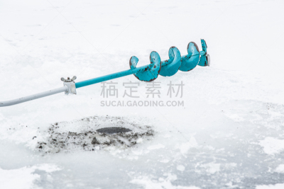 Anglers equipment in the lake ice in winter day. Weekends activities outdoor in cold weather. Winter fishing concept.