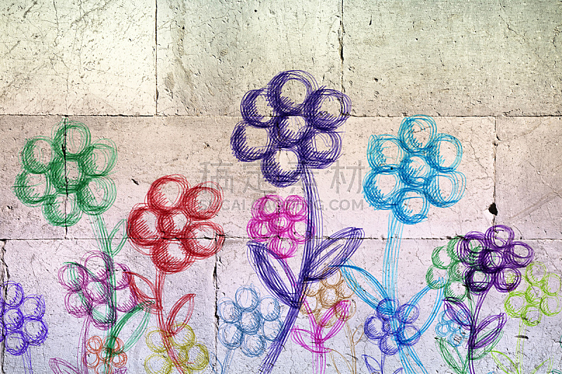 Colored flowers drawn on a white stone wall