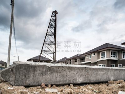 house building at construction site with pile driver and concrete piles