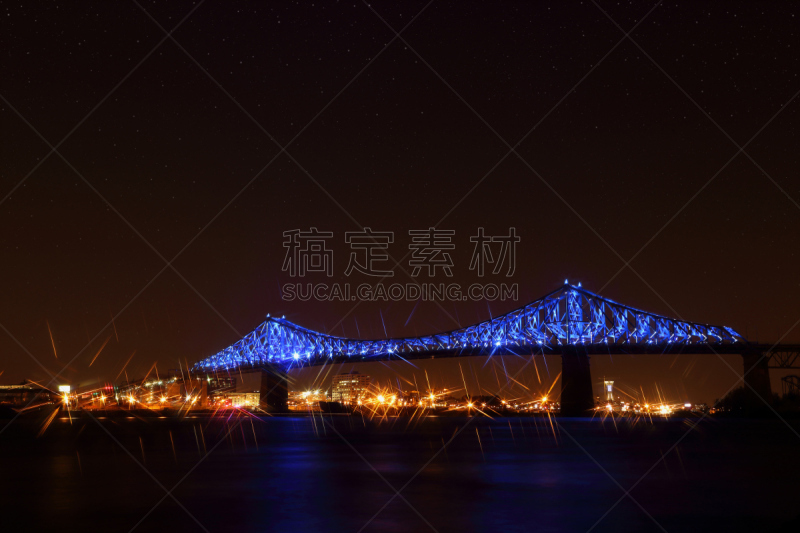 Jacques Cartier Bridge Illumination in Montreal, reflection in water. Montreal’s 375th anniversary. luminous colorful interactive Jacques Cartier Bridge. Bridge panoramic colorful silhouette by night.