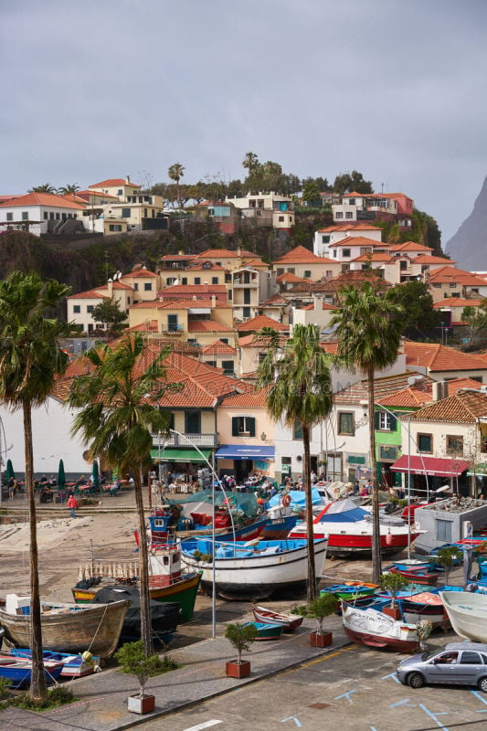 View of Câmara de Lobos in Madeira with Cape Girão on the background and boats at the marina