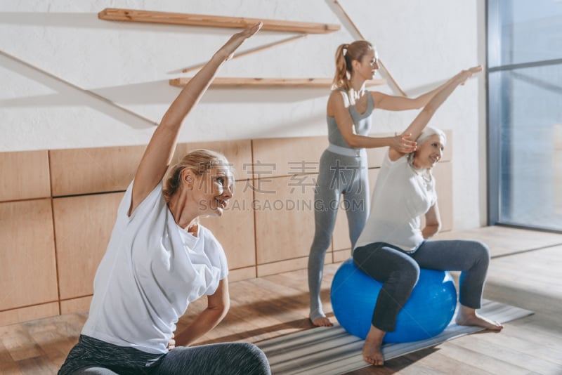 group of senior people exercising with fitness balls in studio