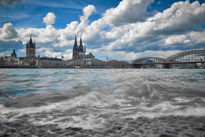 Aussicht in Köln am Rhein auf die Kölner Altstadt mit dem Dom und der St. Martins Kirche bei blauem Himmel und lockeren Wolken.