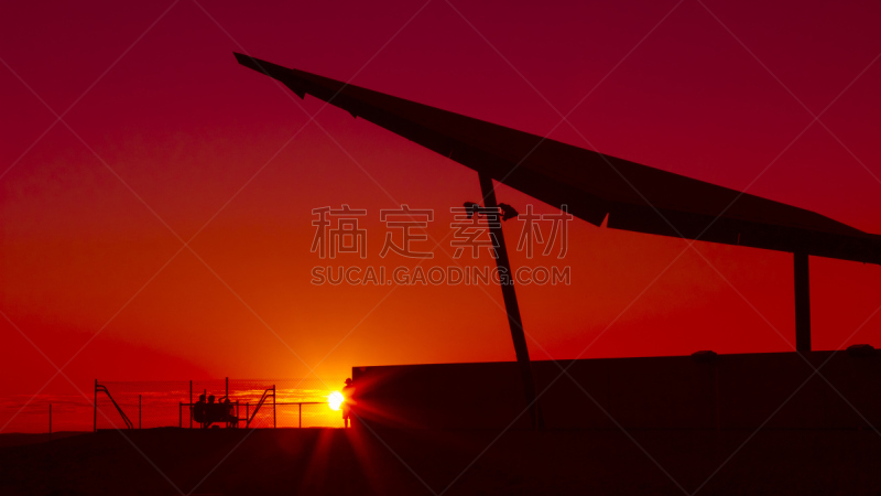 Travelers enjoying a blazing red sunset sky in the outback. Broken Hill, New South Wales, Australia.