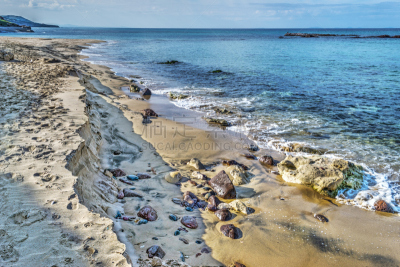 rocks and sand by the shore in Castelsardo