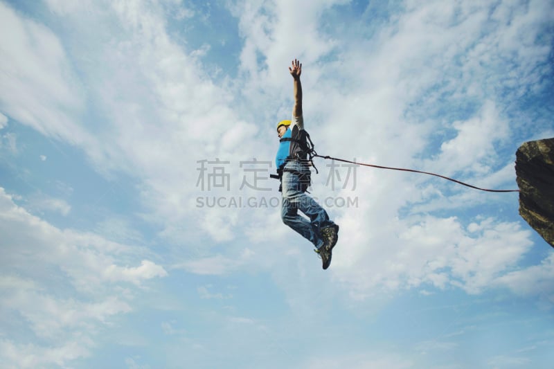 A man jumps into a canyon from a cliff.