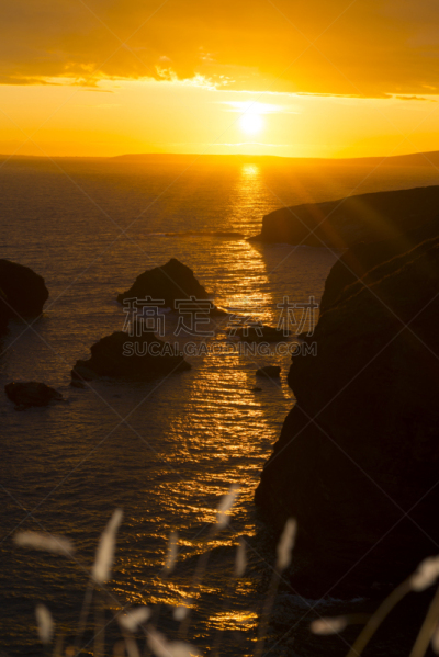 sunset over the coastal rocks with wild highl