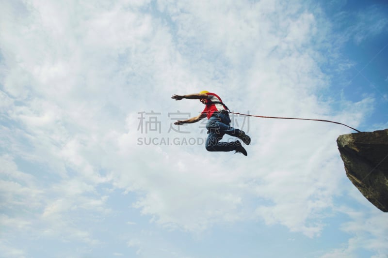 A man jumps into a canyon from a cliff.