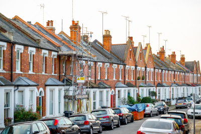 Traditional Victorian terraced houses, one covered with scaffolding in London