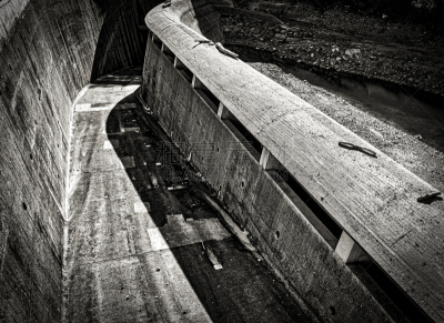 une vue en noir et blanc du déversoir en béton d’un barrage