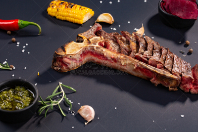 格子烤肉,t骨牛排,食盐,迷迭香,红辣椒粉,大蒜,玉米,开胃酱,黑色背景,切块