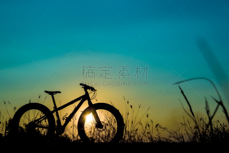 beautiful sunset sky and mountain bike silhouette , silhouette fat bike