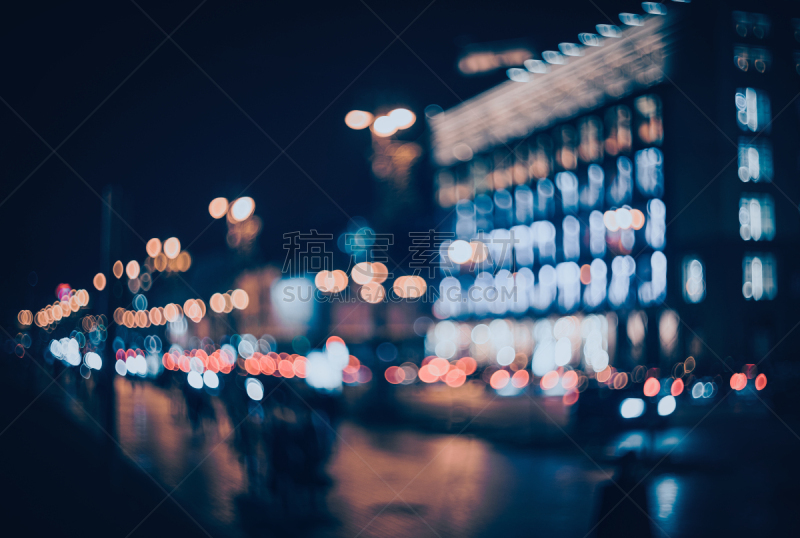 Blurred city at night. Bokeh. Beautiful abstract background with defocused buildings, cars, city lights, people. Colorful bokeh background with urban night scene. Design. Concept backdrop. Vintage
