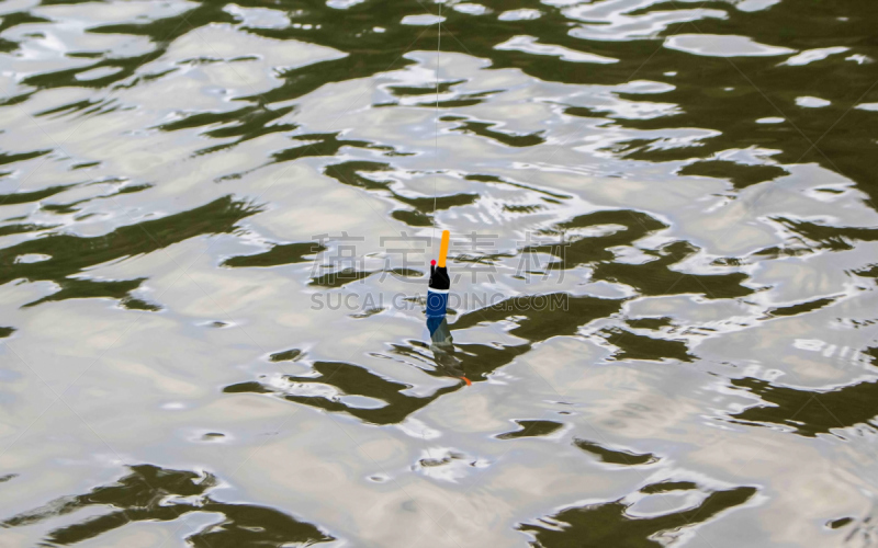 Fishing float in water. Rippled water of forest lake. Fishing weekend concept photo.