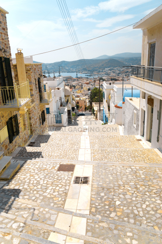 Сozy narrow streets of the old resort European town in a summer sunny day. Low-rise buildings of local residents, small cafes and hotels. Ermoupolis town on Syros island, Cyclades, greece.