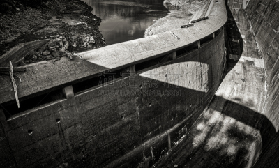 une vue en noir et blanc du déversoir en béton d’un barrage