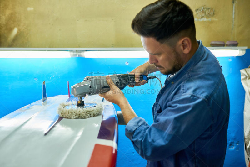 Man Polishing Custom Surfing Board