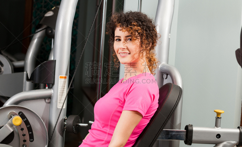 Attractive female smiling and exercising in the gym